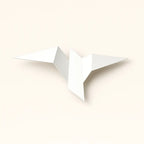 Minimalist origami-style LED wall light with outstretched wings, softly illuminated, metallic-acrylic finish.