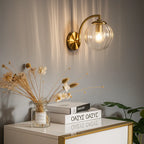 This retro brass wall light with glass globe emits a warm, welcoming ambient glow.
