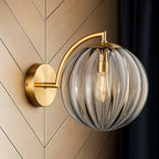 ORLUNE HOME brass wall light: gold arm, globe glass, exposed bulb—chic illumination defined.