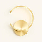 Modern gold circular LED wall light with open minimalist design, wall-mounted, against light background.