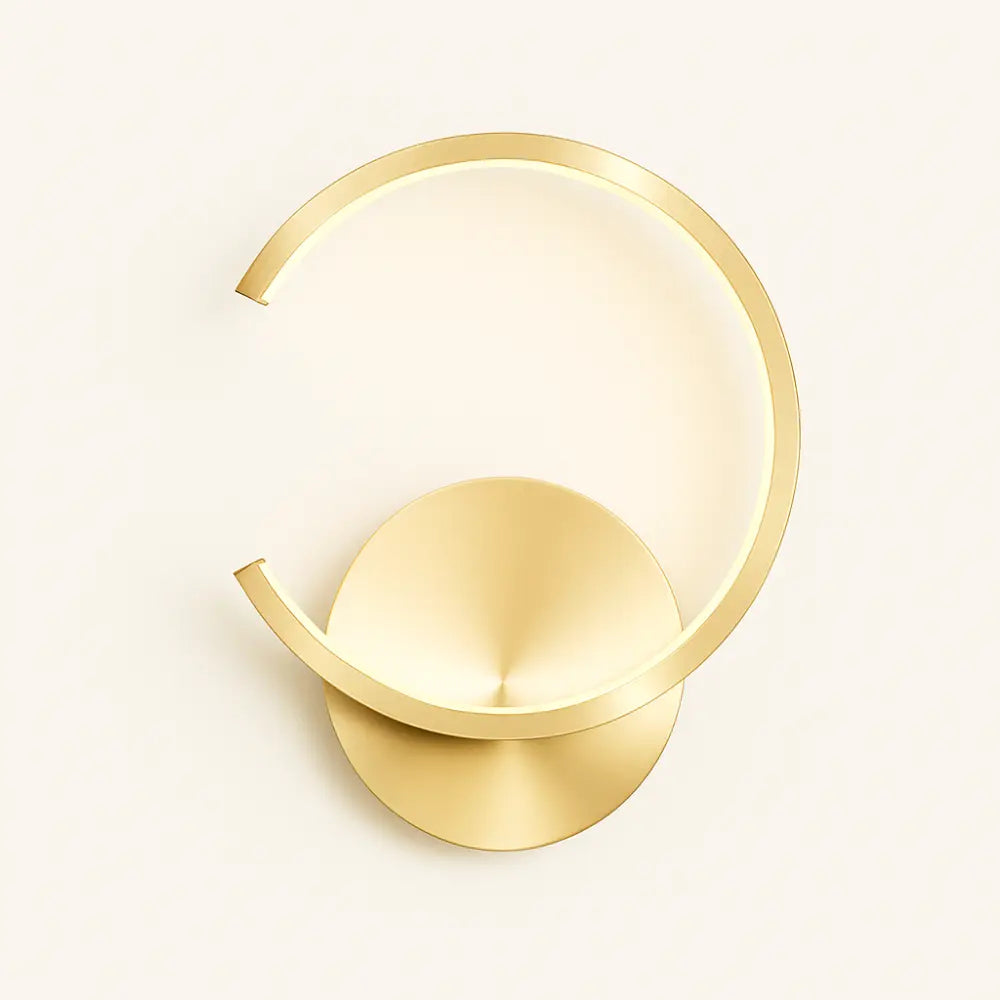 Modern gold circular LED wall light with open minimalist design, wall-mounted, against light background.