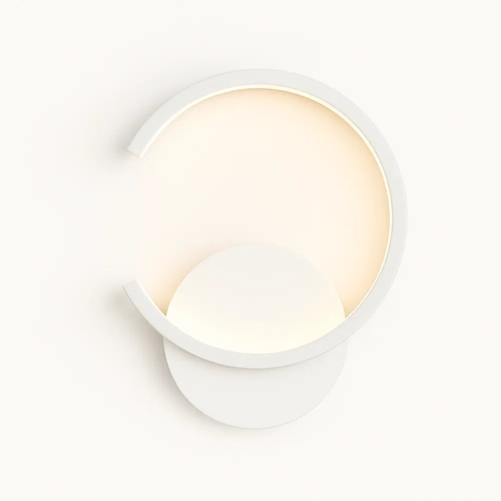 Modern circular wall light with metal crescent frame, round base, and soft LED backglow.