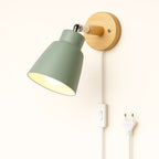 Softly glowing, the green-shaded wall light casts a warm, inviting Nordic ambiance.