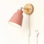 Soft pink light glows warmly from the minimalist wooden wall lamp, illuminating with cozy charm.