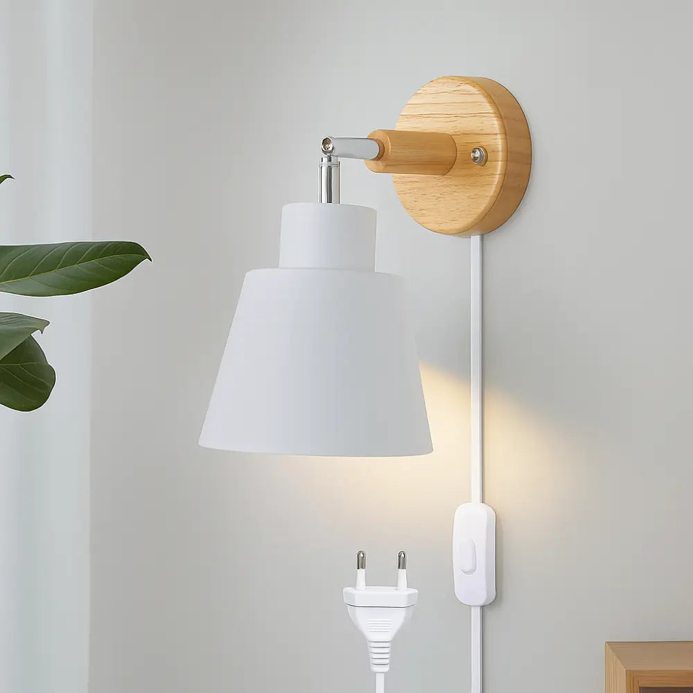Soft illumination glows from a wooden wall light with a minimalist white shade and cord.
