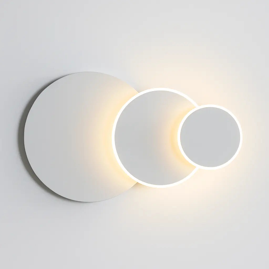Modern round LED wall sconce with three intersecting white circles and softly glowing edges.