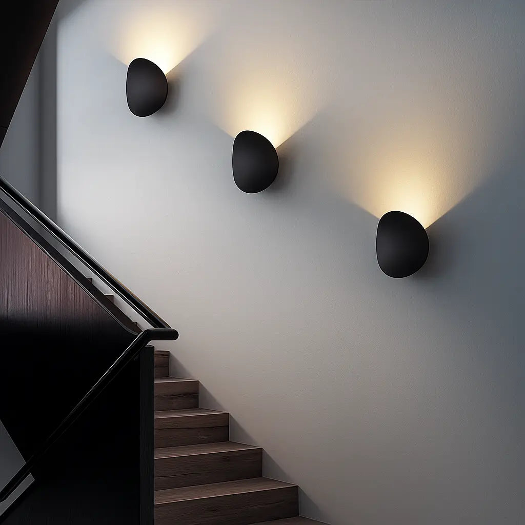 Warm LED wall sconces cast upward glow, enhancing staircase visibility and ambiance beautifully.