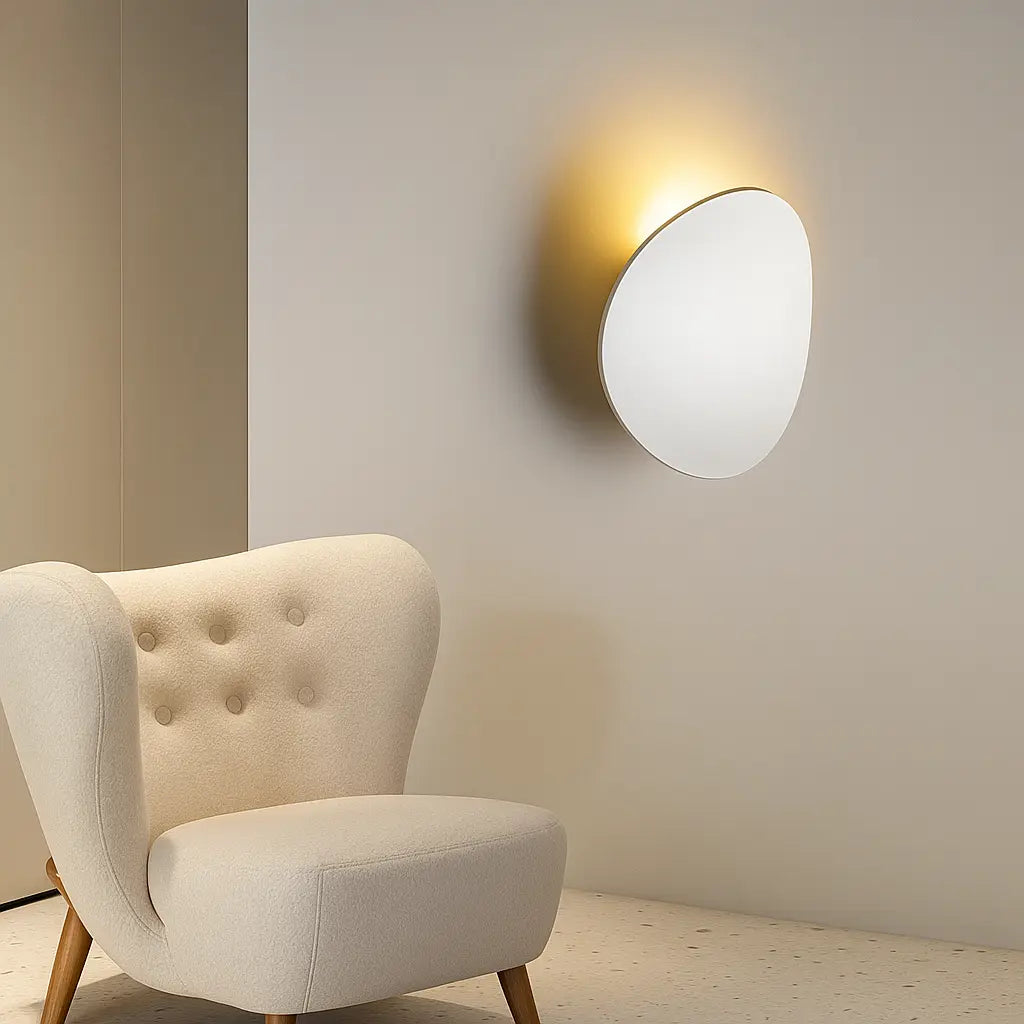 A Modern Aluminum Round LED Wall Sconce emits soft, warm light against a cream-colored wall.