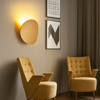Modern Aluminum Round LED Wall Sconce mounted on wall, emitting soft ambient light.