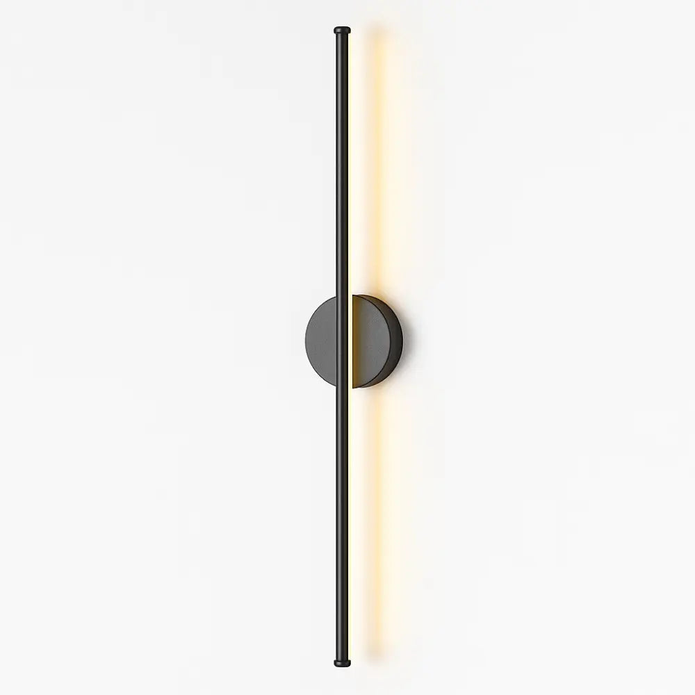 Warm LED light glows softly from a sleek black matte wall fixture, illuminating the space.