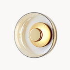 Round LED wall light with gold metallic center and tinted glass ring, glass and aluminum.
