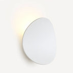 Sleek round aluminum LED wall sconce emits warm light, mounted on a white wall.