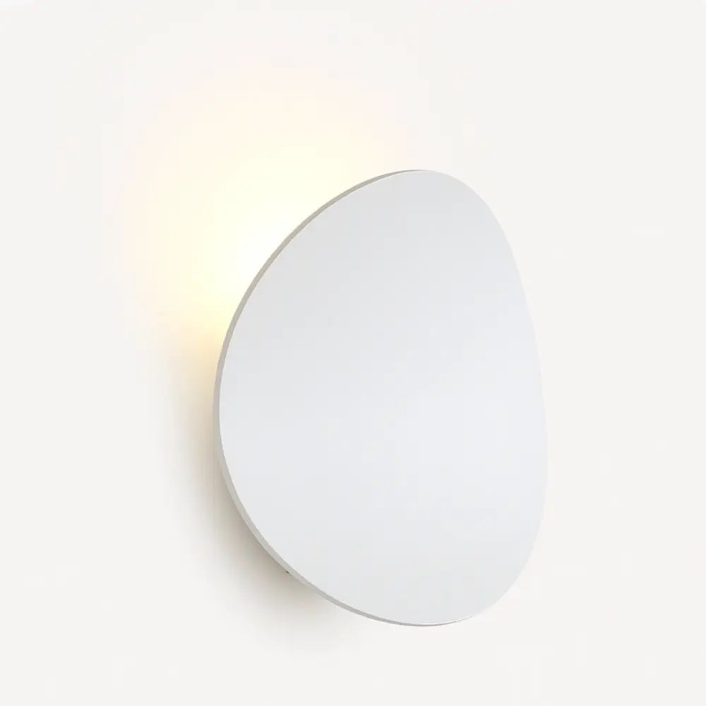 A round LED wall sconce casts a soft, warm glow—perfect for modern lighting.
