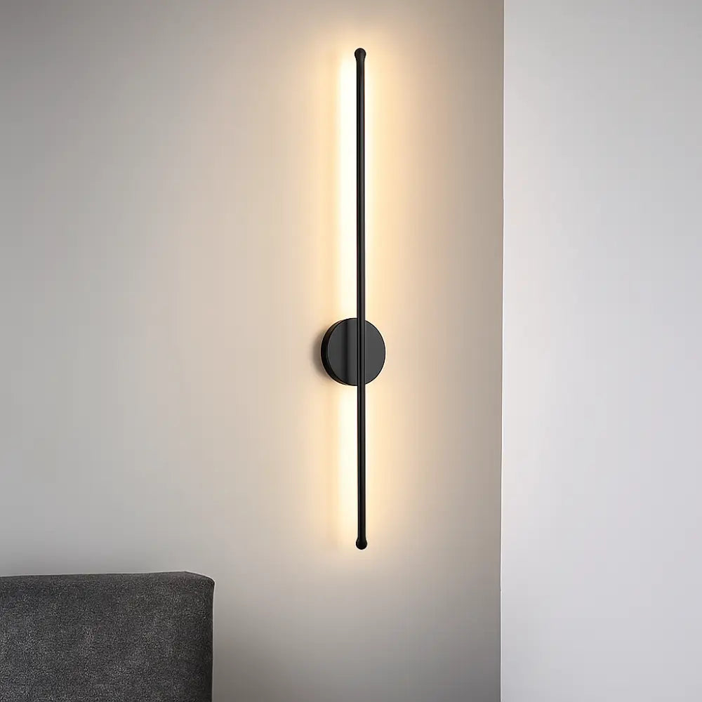 Applique murale LED noire aluminium au design vertical, éclaire chaleureusement et modernise la salle de bain.