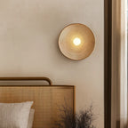 A wavy resin LED wall light in Wabi-Sabi style glows warmly against a beige wall.