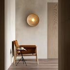 The Wavy Resin LED Wall Light in Wabi-Sabi style emits warm light on neutral walls.
