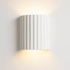 Soft indirect up and down LED wall lighting, modern ribbed white half-cylinder design.