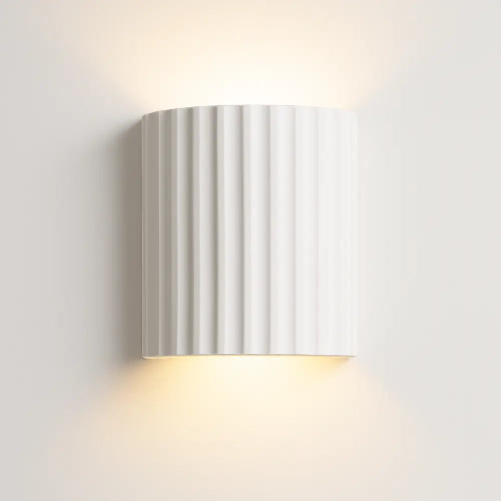 Soft indirect up and down LED wall lighting, modern ribbed white half-cylinder design.