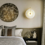 A circular LED wall lamp with a minimalist design, glowing softly against a neutral wall.
