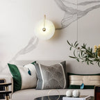 Circular LED wall lamp with a minimalist design, mounted on the wall, glowing softly.