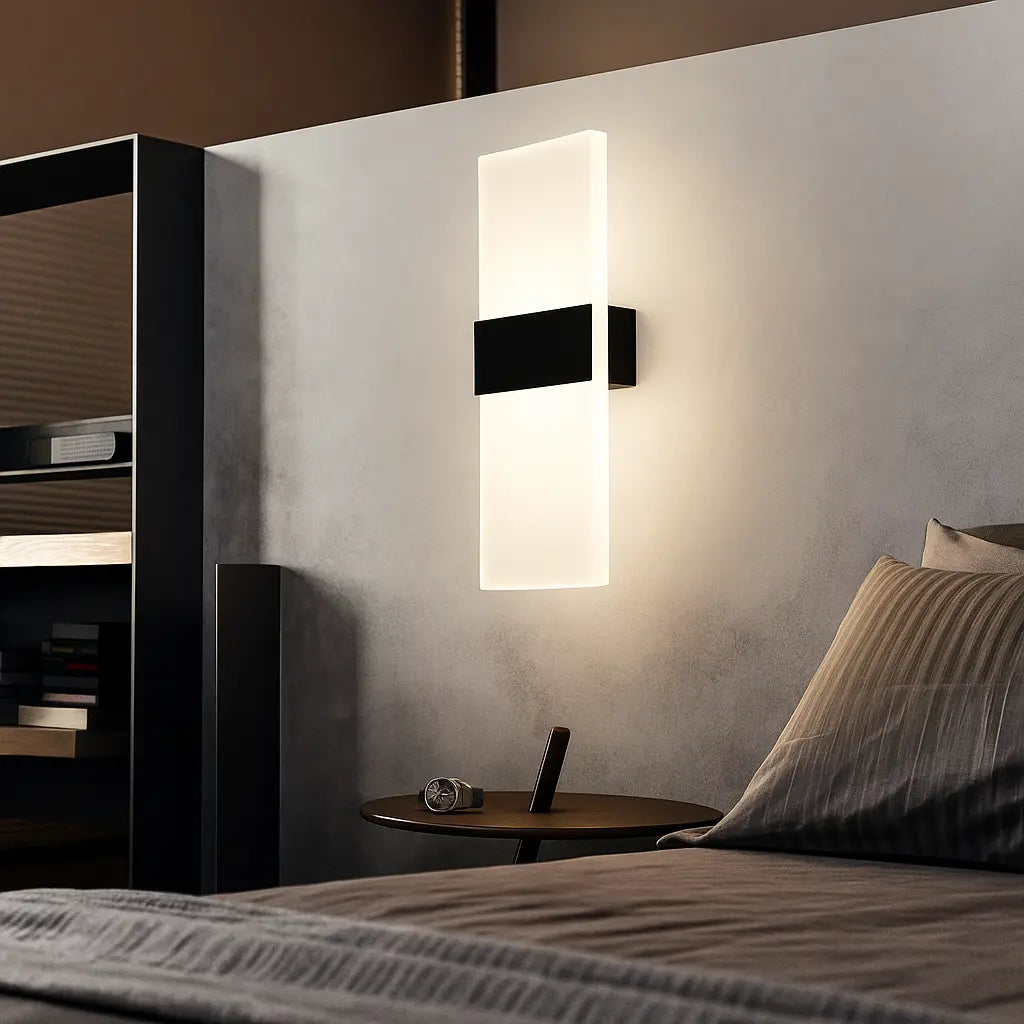 Rectangular LED wall sconce with brushed metal and acrylic design, mounted on a plain wall.