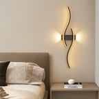 ORLUNE HOME LED wave wall lights create a warm, contemporary glow above the bed.