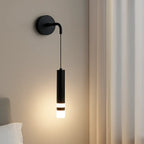 Sleek black cylindrical aluminum wall light with integrated LED, emits soft warm glow.