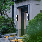 Aluminum cylindrical outdoor wall light, modern design, mounted beside a tall dark door.