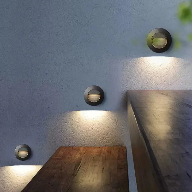 Aluminum outdoor wall spotlight with IP65 rating, modern design, casts warm downward glow.
