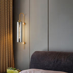 An elegant modern industrial glass wall light with a cylindrical shade in soft, warm illumination.
