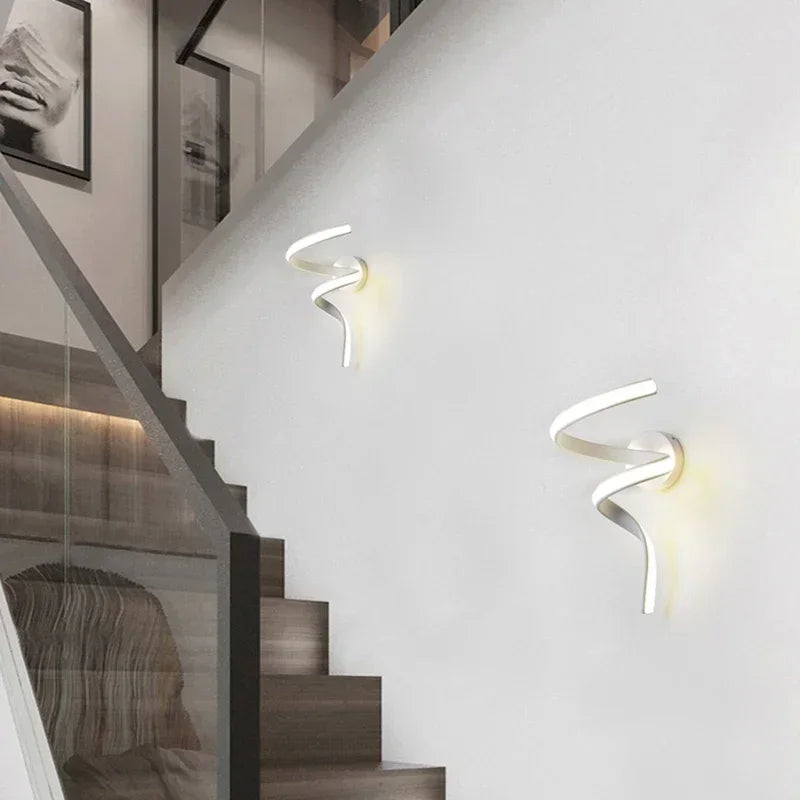 Deux appliques murales LED minimalistes diffusent une lumière douce sur un mur blanc.