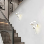 Deux appliques murales LED minimalistes diffusent une lumière douce sur un mur blanc.
