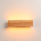 Luminaire en bois avec rainures, éclairage LED chaud diffusé vers le haut et le bas.