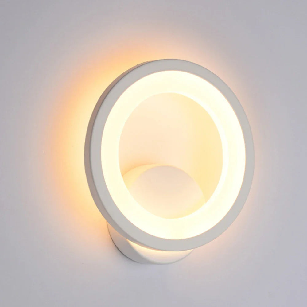 Modern white LED wall light with glowing ring creates a soft, warm halo effect.