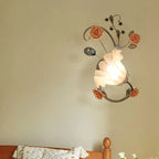 Applique murale en verre givré, décoration florale céramique, diffuse une lumière blanche douce.