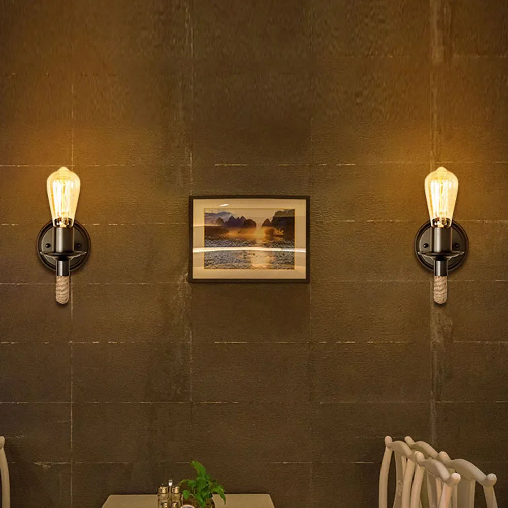 Two industrial hemp wall sconces emit a warm, inviting glow on the softly lit wall.