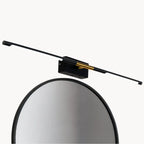 Applique murale LED noire et dorée, élégante, linéaire, installée pour salle de bain.