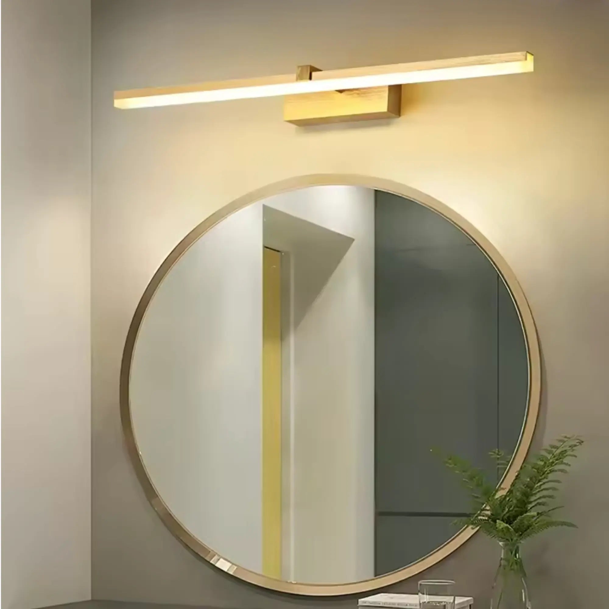 Luminaire mural LED en acier élégant et moderne installé au-dessus d'un miroir rond.