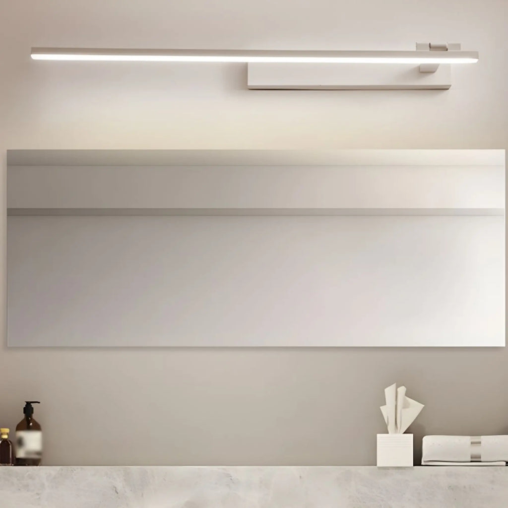 Un luminaire LED linéaire orientable, fixé au-dessus d'un miroir salle de bain.
