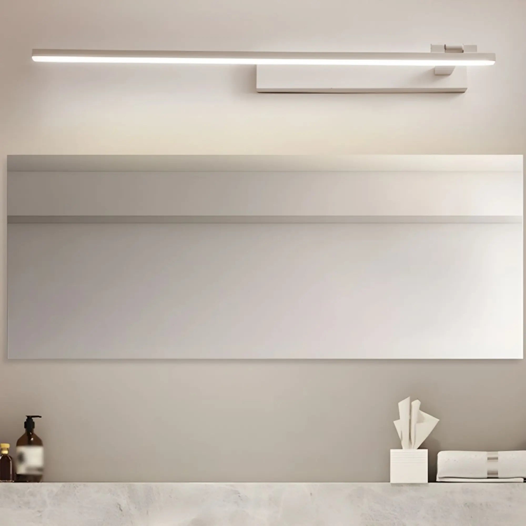 Un luminaire LED linéaire orientable, fixé au-dessus d'un miroir salle de bain.