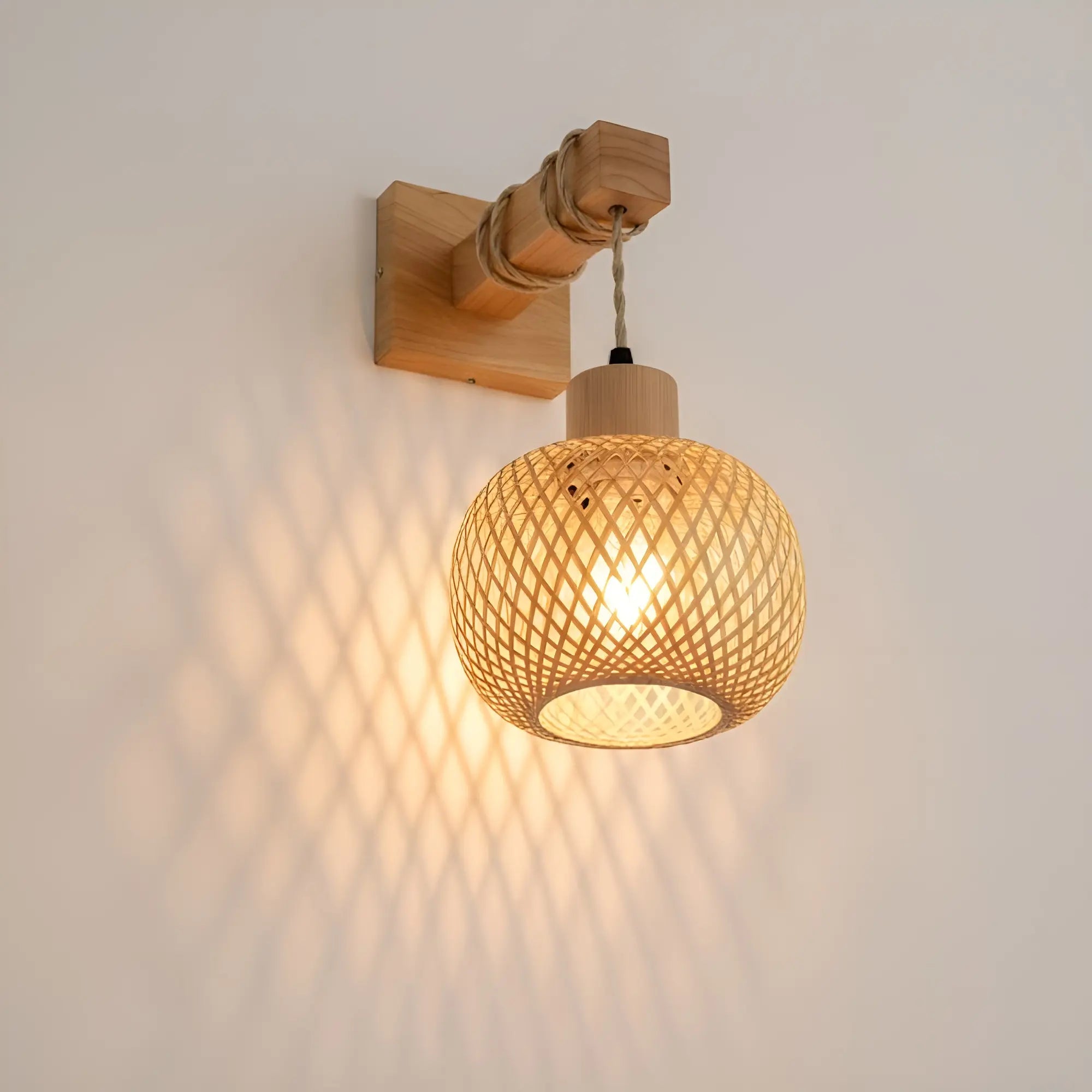 Warm light shines through woven rattan, casting beautiful patterned shadows on white walls.