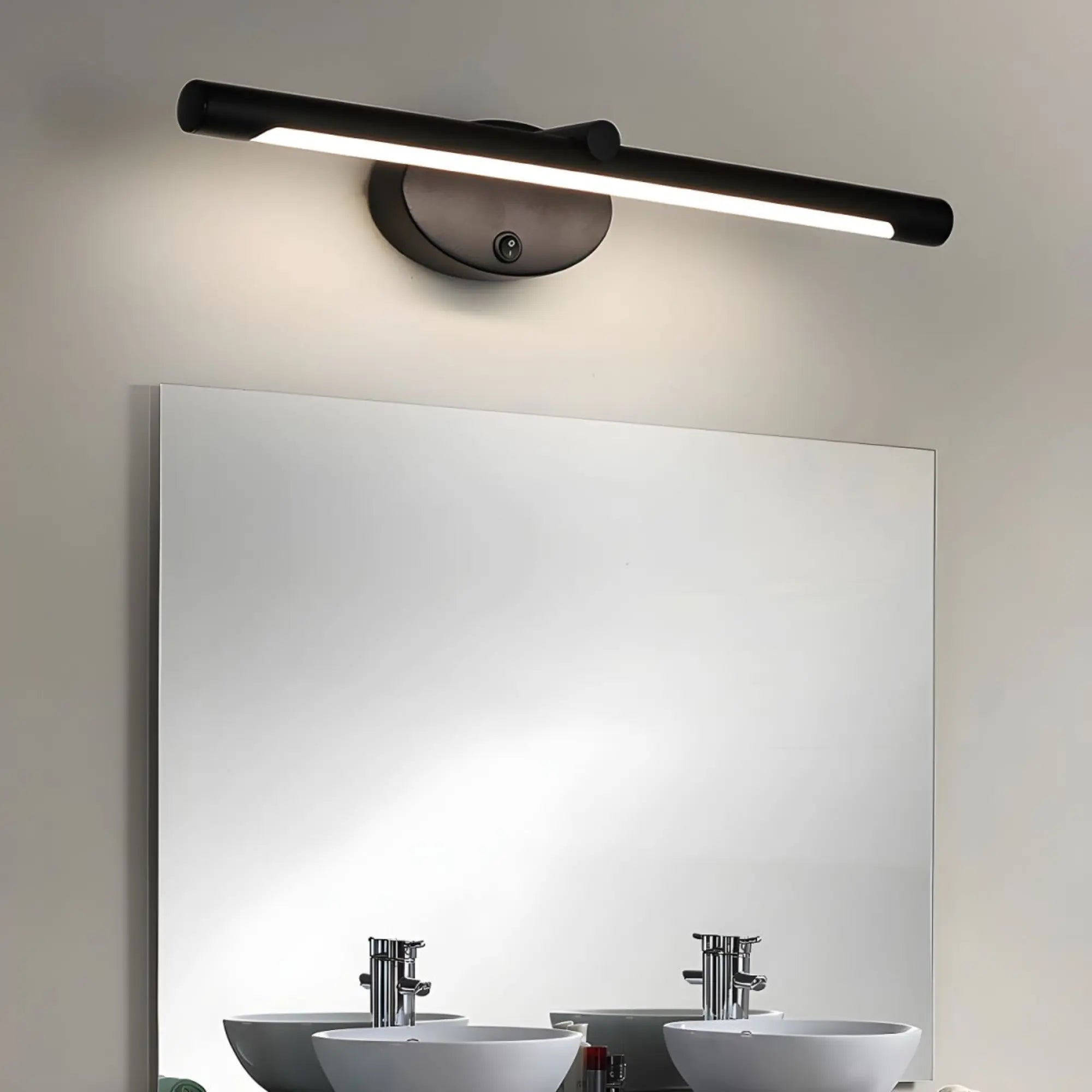 Applique murale LED tactile noire, installée au-dessus d'un miroir, diffuse une lumière intégrée.