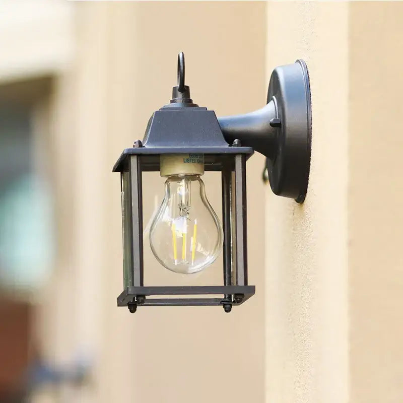 Black aluminium wall light with clear glass and visible bulb, vintage-inspired, durable exterior style.