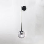 Black and gold wall sconce with spherical glass shade and sleek modern metal design.