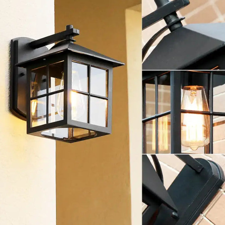 Black metal and clear glass vintage lantern wall light with a glowing bulb, retro details.