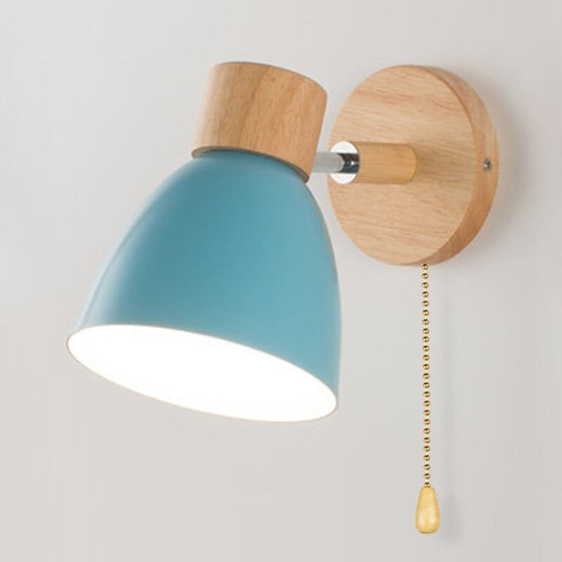 Blue-shaded Scandinavian wall light with wooden base, pull chain, and 360° rotation.