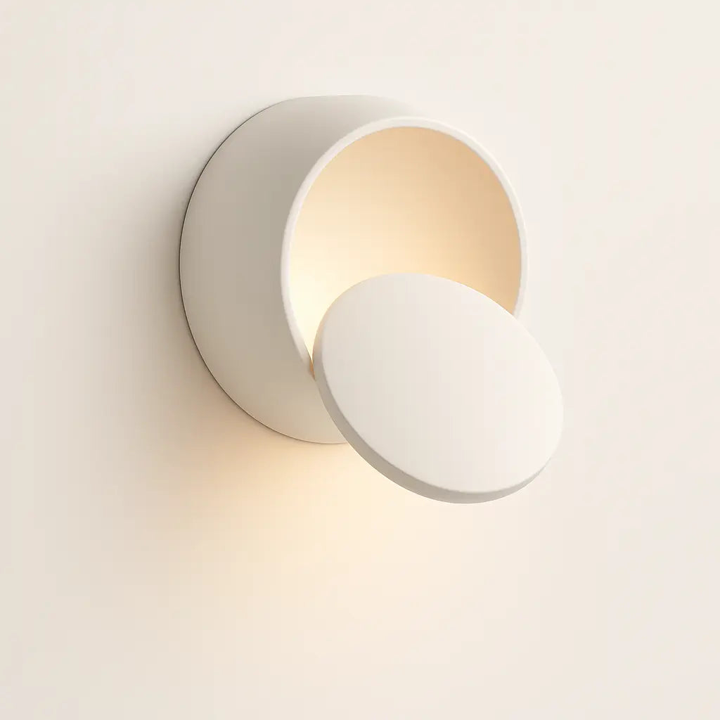 Soft, warm LED light radiates from a sleek, modern circular wall sconce design.