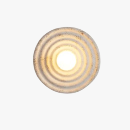 Circular glass wall light with concentric ridges, emits a warm yellow glow.