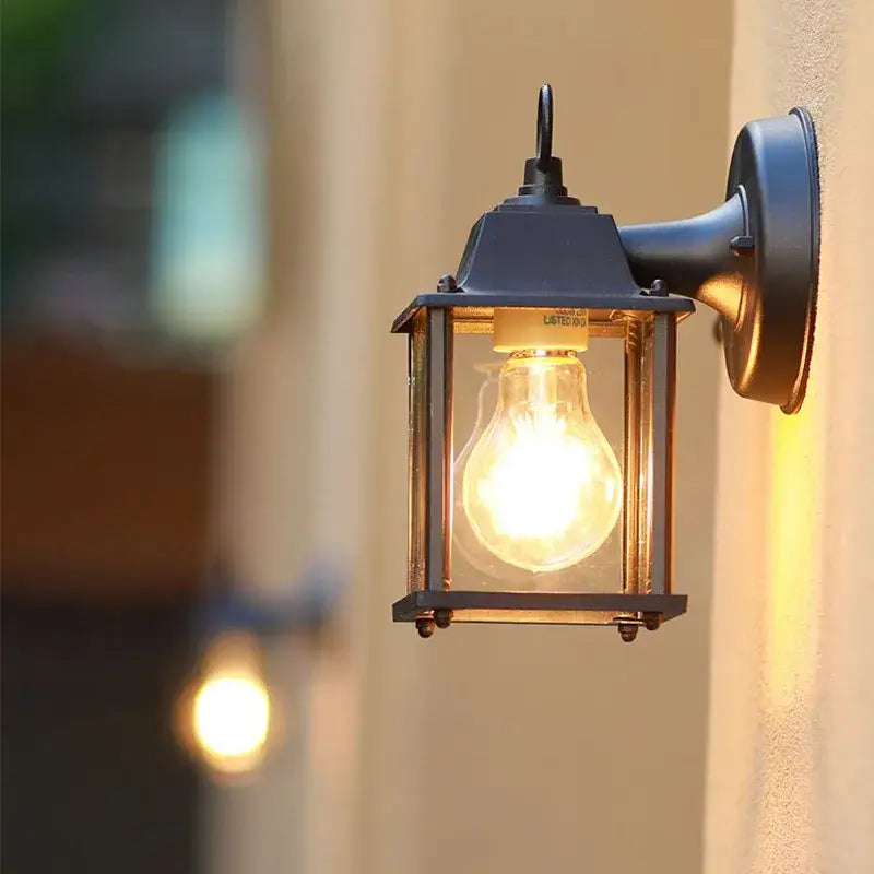 Close-up of the Black Aluminium Outdoor Wall Light with Clear Glass E27 on a beige wall.