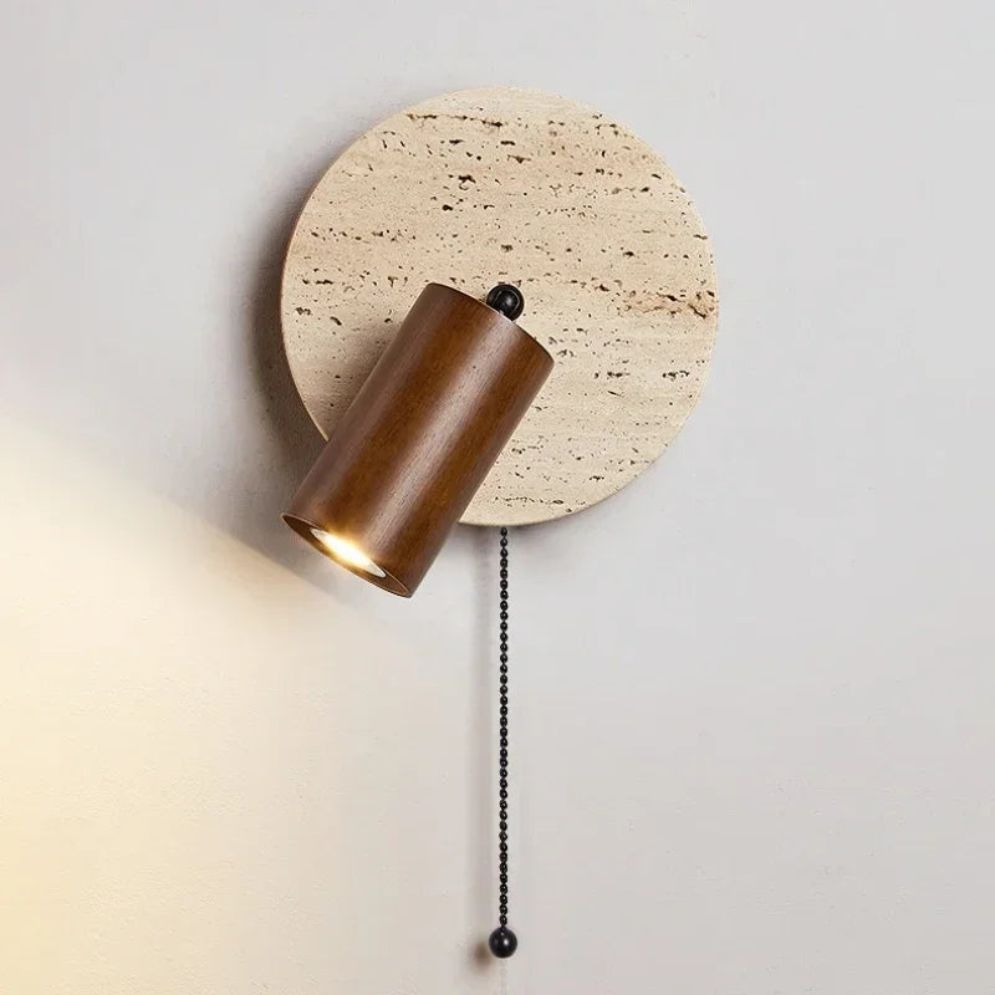 Cylindrical wooden wall light with round beige stone backplate and hanging pull chain switch.